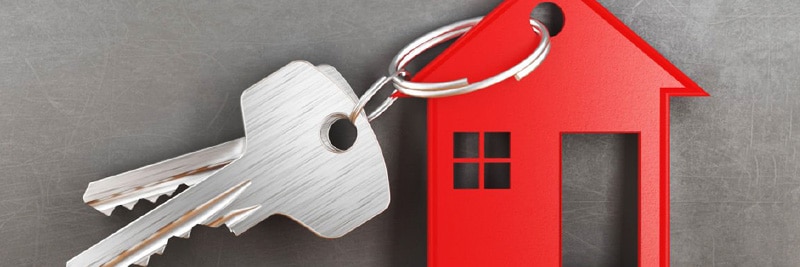 House keys attached to a miniature red home keychain.